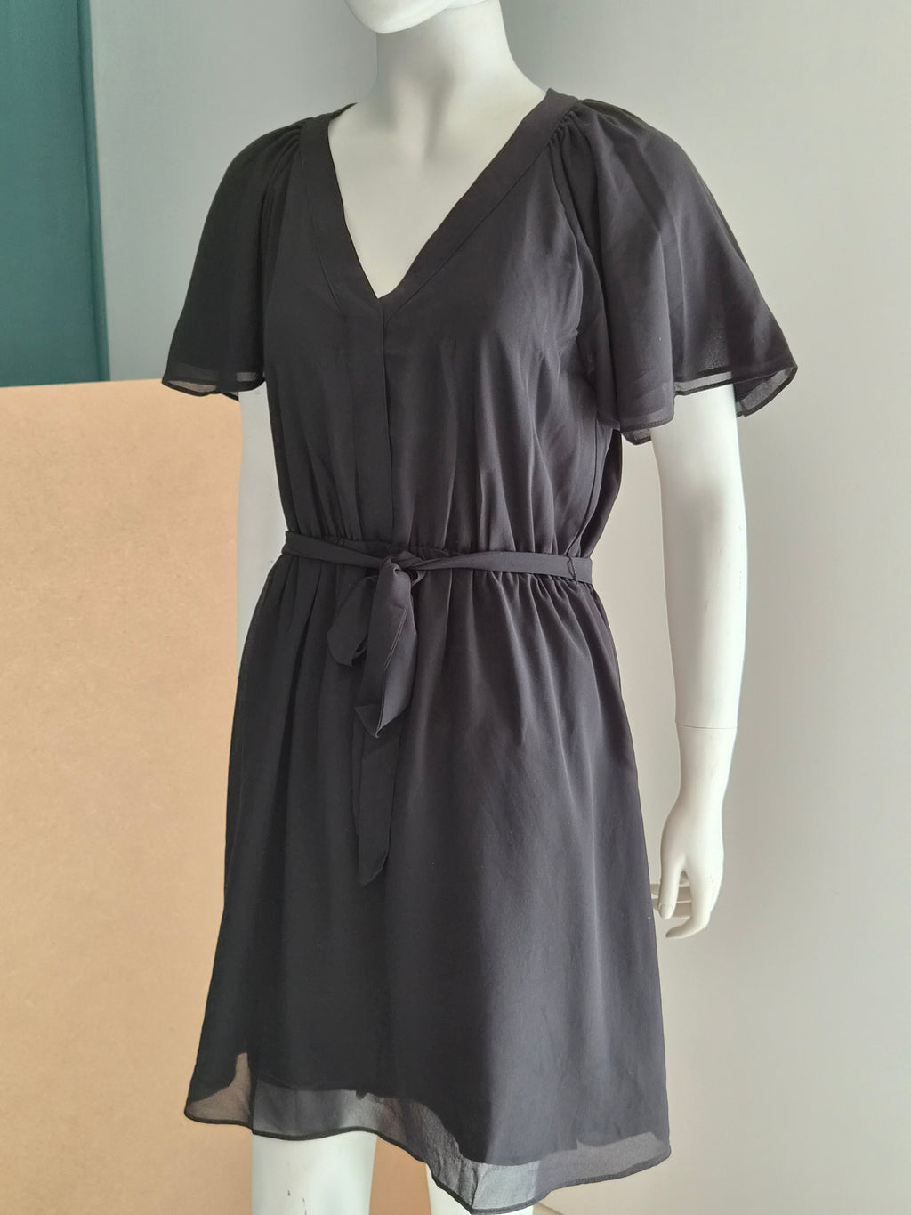Robe H&M noire - vue de trois quarts avec manches papillon et ceinture nouée